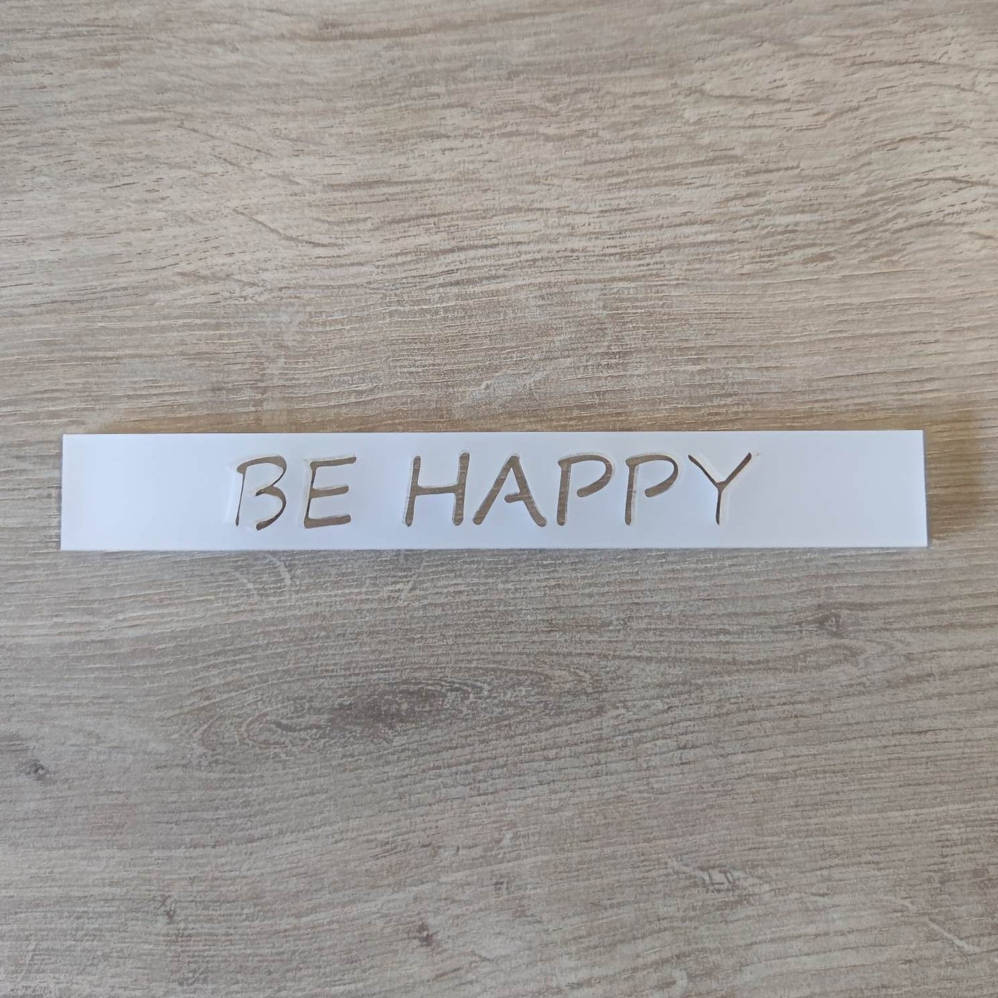 Minimalistischer Acryl-Easy-Stick 'BE HAPPY' von Easy-Sticks, auf Holzoberfläche präsentiert, ideal für kreative DIY-Projekte.