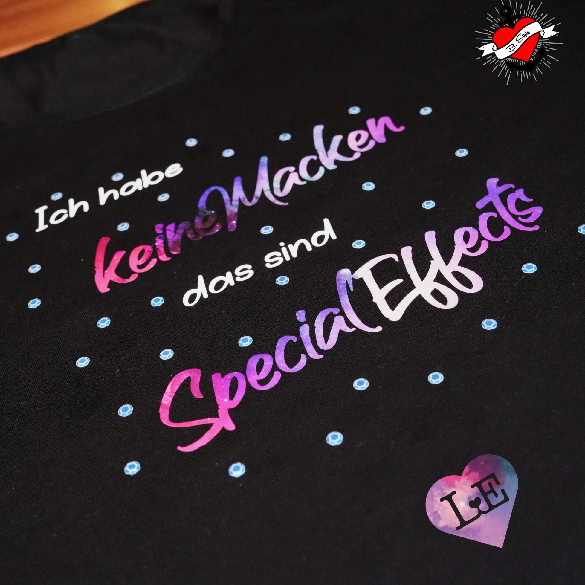 T-Shirt in Schwarz mit buntem Aufdruck 'Ich habe kleine Macken das sind Special Effects' von easy-sticks, perfekt für kreative Ausdrucksmöglichkeiten.