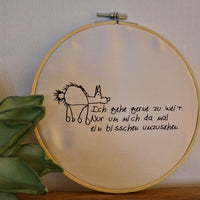 Ein kreatives Stickbild mit dem Spruch 'Ich gehe gerne zu weit. Nur um mich da mal ein bisschen umzusehen.' von easy-sticks, umgeben von einer grünen Pflanze im Hintergrund.