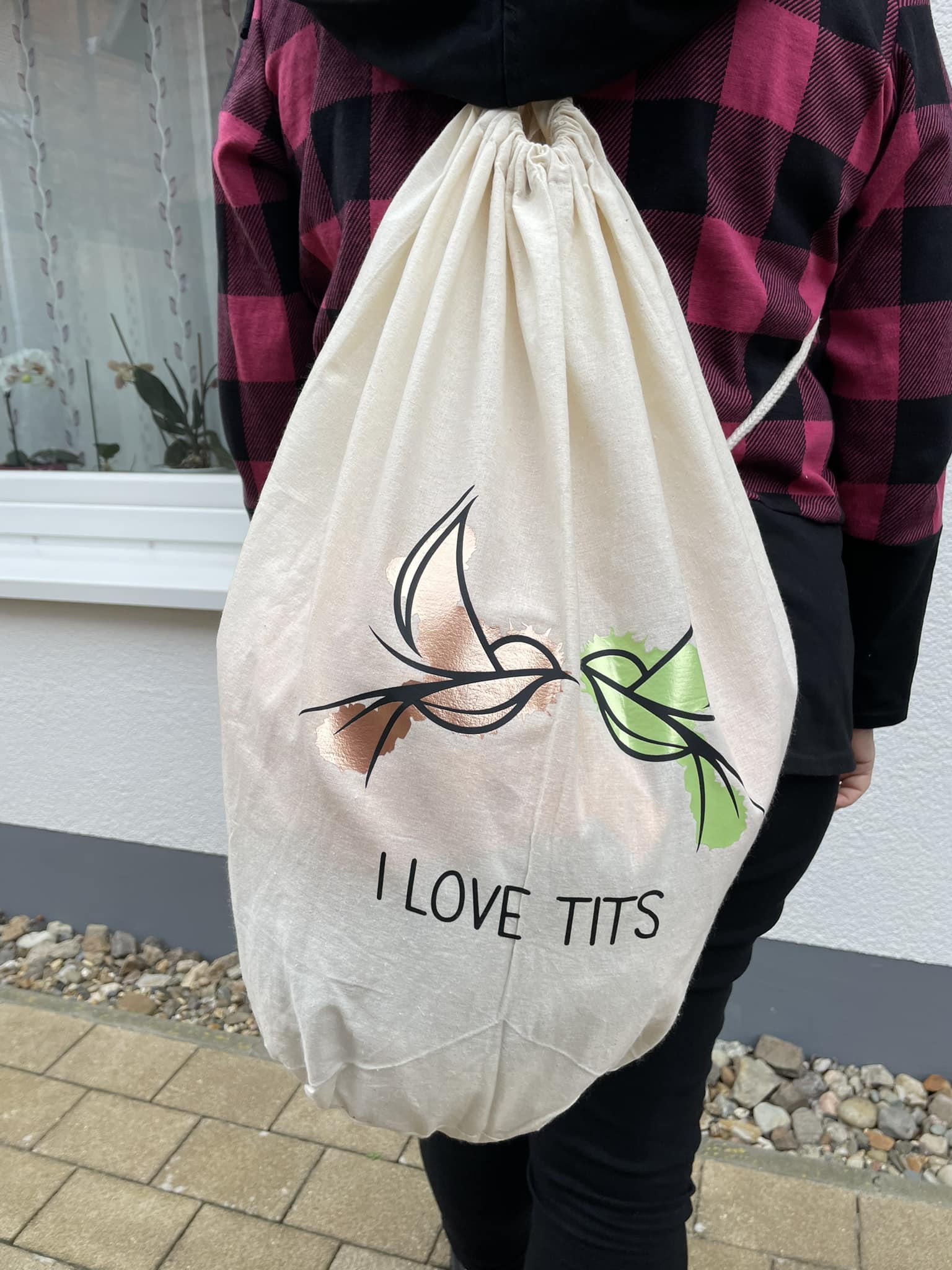 Ein kreativer Beutel mit dem Aufdruck "I love Tits", getragen von einer Person in einem gestreiften Pullover. Dieses Produkt von easy-sticks ist perfekt für deine DIY-Projekte und verdeutlicht den einzigartigen Stil, den du mit der Plotterdatei gestalten kannst.