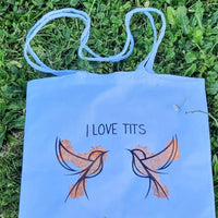 Farbenfroher Stoffbeutel mit dem Schriftzug "I love Tits" von easy-sticks, der in der Natur aufgenommen wurde, ideal für kreative Unternehmungen.