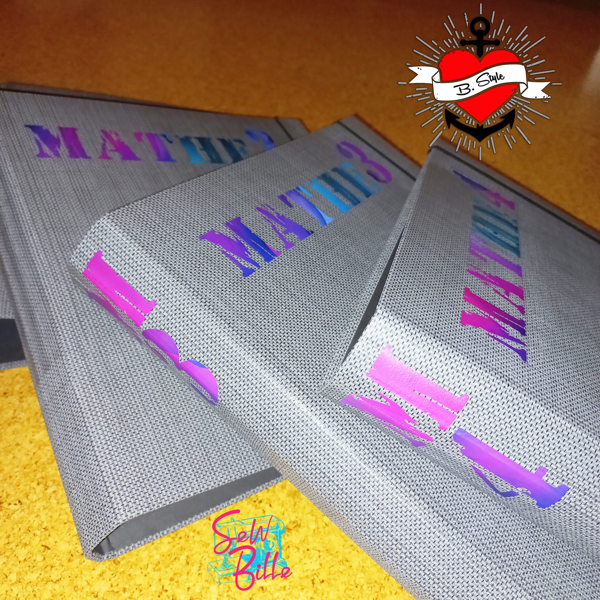 Industrielle Stempel Schriftart Plotterdatei von easy-sticks, präsentiert auf stilvollen grauen Ordnern mit leuchtenden Farbeffekten, ideal für kreative Bastelprojekte.