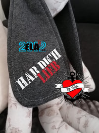 Industrielle Stempel Schriftart Plotterdatei von easy-sticks, veredelt auf einer grauen Textiloberfläche mit einem inspirierenden Spruch, hervorragend für persönliche DIY-Projekte.