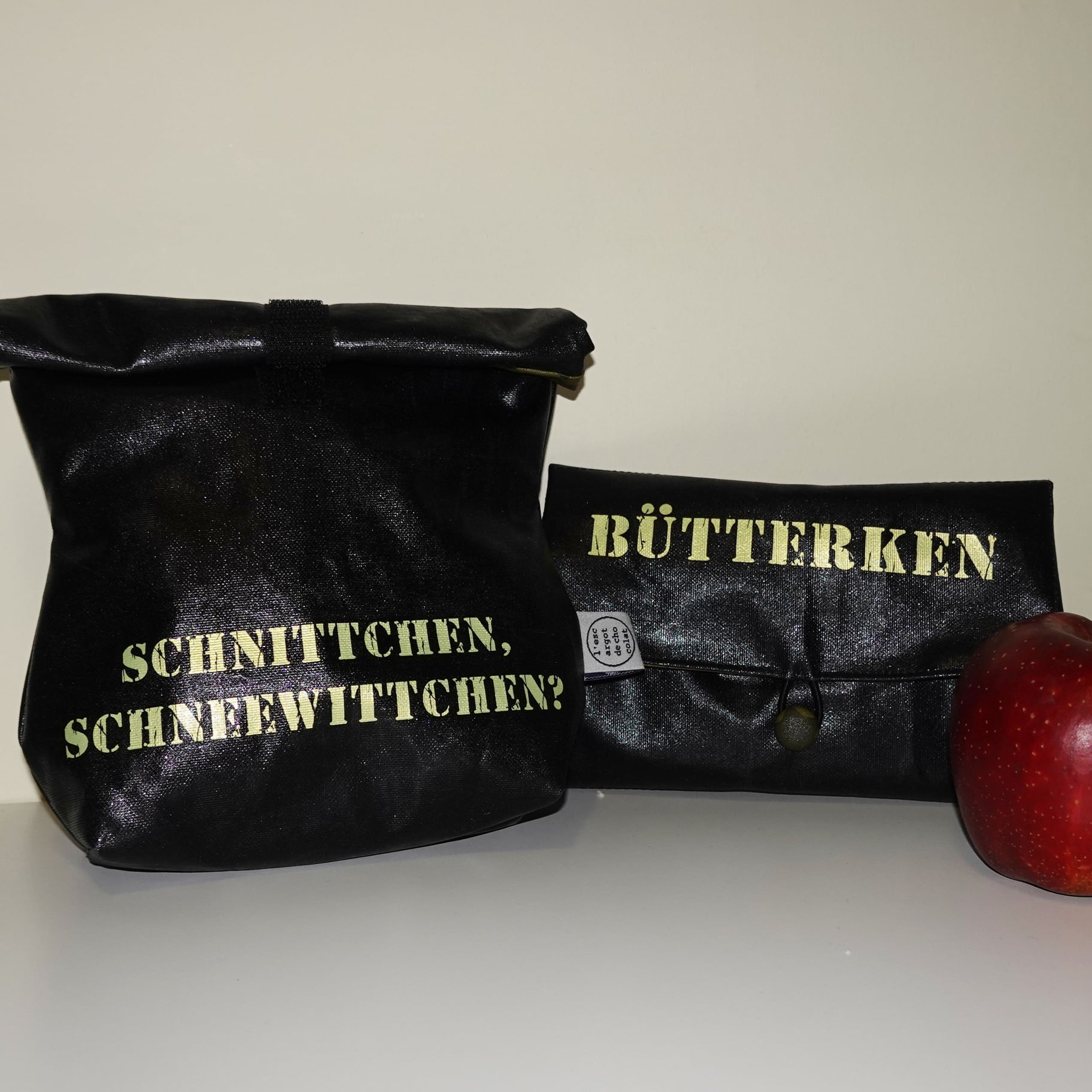 Schwarze Taschen mit goldenen Schriftzügen, gestaltet mit der Industrial Stempel Schriftart von easy-sticks, die zur Aufbewahrung von Lebensmitteln dienen.