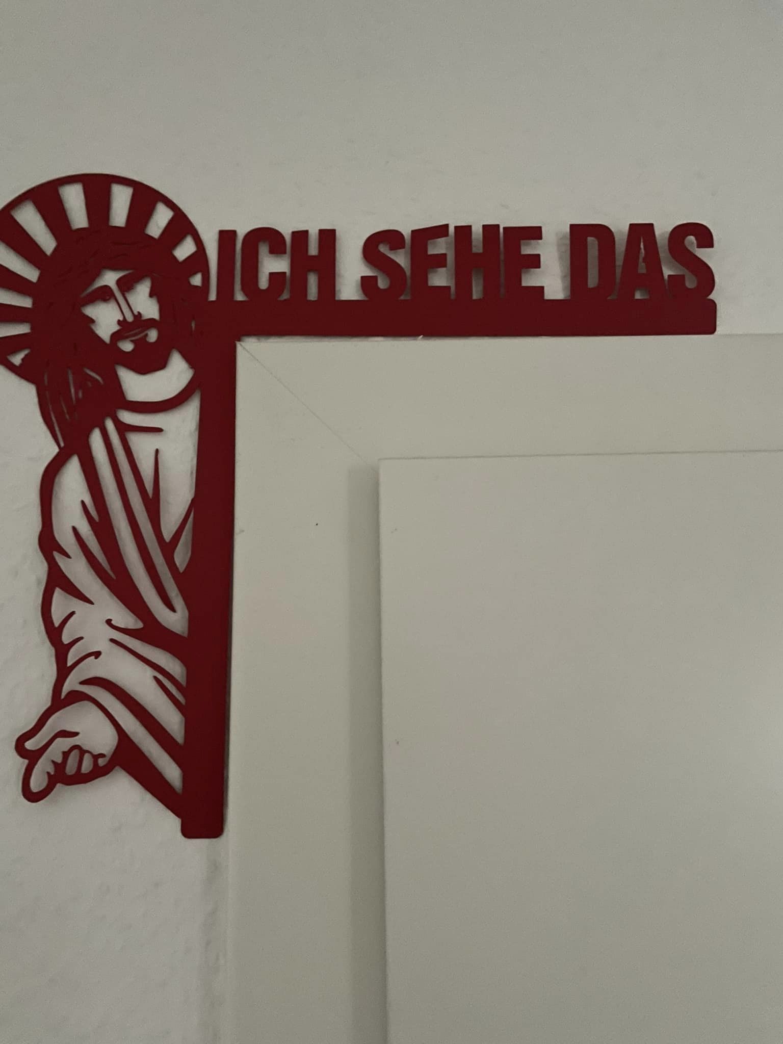 Ein ästhetisches Wandobjekt "Jesus, ich sehe das" von easy-sticks, das an einer Wand hängt und durch seine lebendige rote Farbe auffällt.