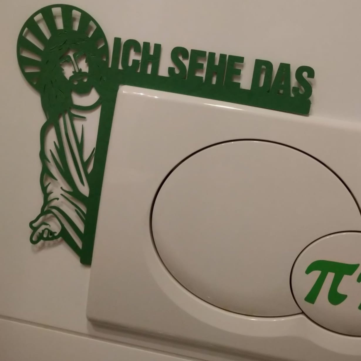 Grünes Schild mit der Jesusfigur und dem Schriftzug "Ich sehe das" neben einem Schalter, von easy-sticks.