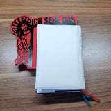 Praktisches Lesezeichen im Stil von "Jesus, ich sehe das" von easy-sticks, angeheftet an einem weißen Buch, kombiniert mit rotem und schwarzem Design.