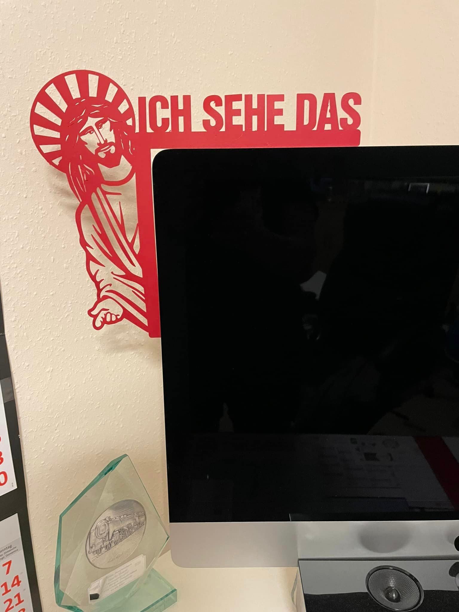Kreative Wanddekoration "Jesus, ich sehe das" von easy-sticks, direkt über einem Computerbildschirm platziert, hervorgehoben durch eine elegante rote Farbe.