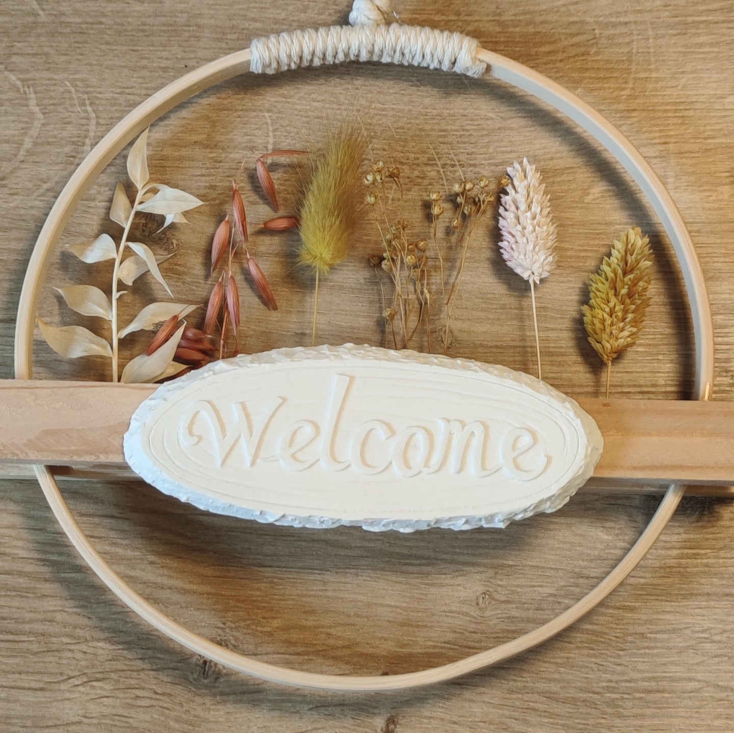 Dekorative Silikon-Gießform "Welcome" von Easy-Sticks, eingebettet in einem Kranz aus Trockenblumen und Ästen, ideal für kreative DIY-Projekte.