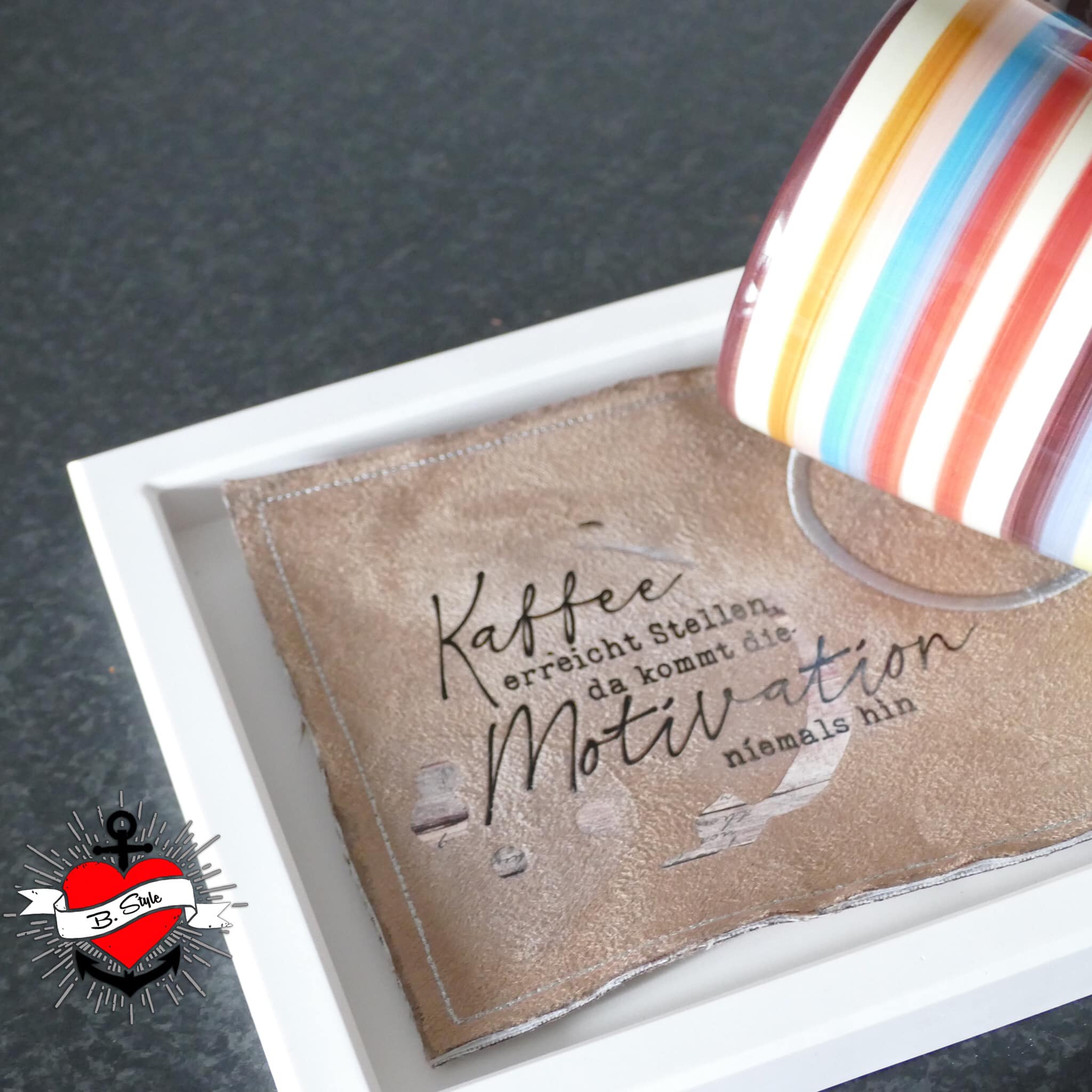 Dekoratives Kaffee Design auf einer Stoffunterlage mit dem Spruch 'Kaffee erreicht Stellen, da kommt die Motivation niemals hin' - perfekt für kreative Projekte mit der 'Kaffee Sprüche Plotterdatei' von easy-sticks.