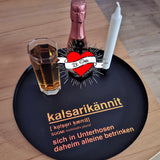 Elegante Stillleben-Präsentation mit einer "Kalsarikännit" Plotter Datei von easy-sticks, auf einem schwarzen Tablett mit einem Glas und einer Flasche. Ein kreatives Projekt-Display.