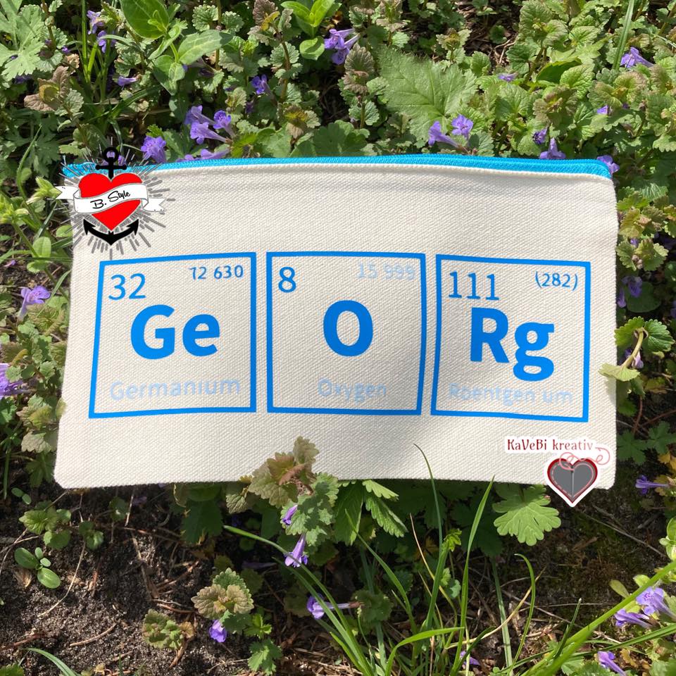 Stylische Tasche mit Elemente des Periodensystems von easy-sticks, mit blauen Symbolen auf natürlichem Stoff und lila Frühlingsblumen im Hintergrund.