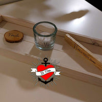 Kerzensprüche für jeden Anlass 1 von easy-sticks: Ein stilvolles Arrangement mit einem Glas Teelicht, einer Holzscheibe mit der Gravur 'Familie' und einem Holzstück mit der Aufschrift 'Home sweet Home'.