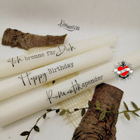 Kerzensprüche für jeden Anlass 1 von easy-sticks: Drei elegante weiße Kerzen mit liebevollen Botschaften wie 'Ich brenne für Dich' und 'Happy Birthday' auf einem naturbelassenen Hintergrund.