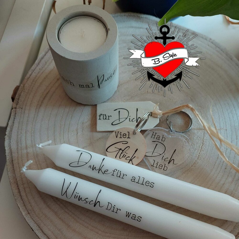 Zwei wunderschöne Kerzen mit inspirierenden Sprüchen und einem grauen Kerzenhalter auf Holzuntergrund, ideal für kreative Projekte mit der Plotterdatei "Kerzensprüche für jeden Anlass 2" von easy-sticks.