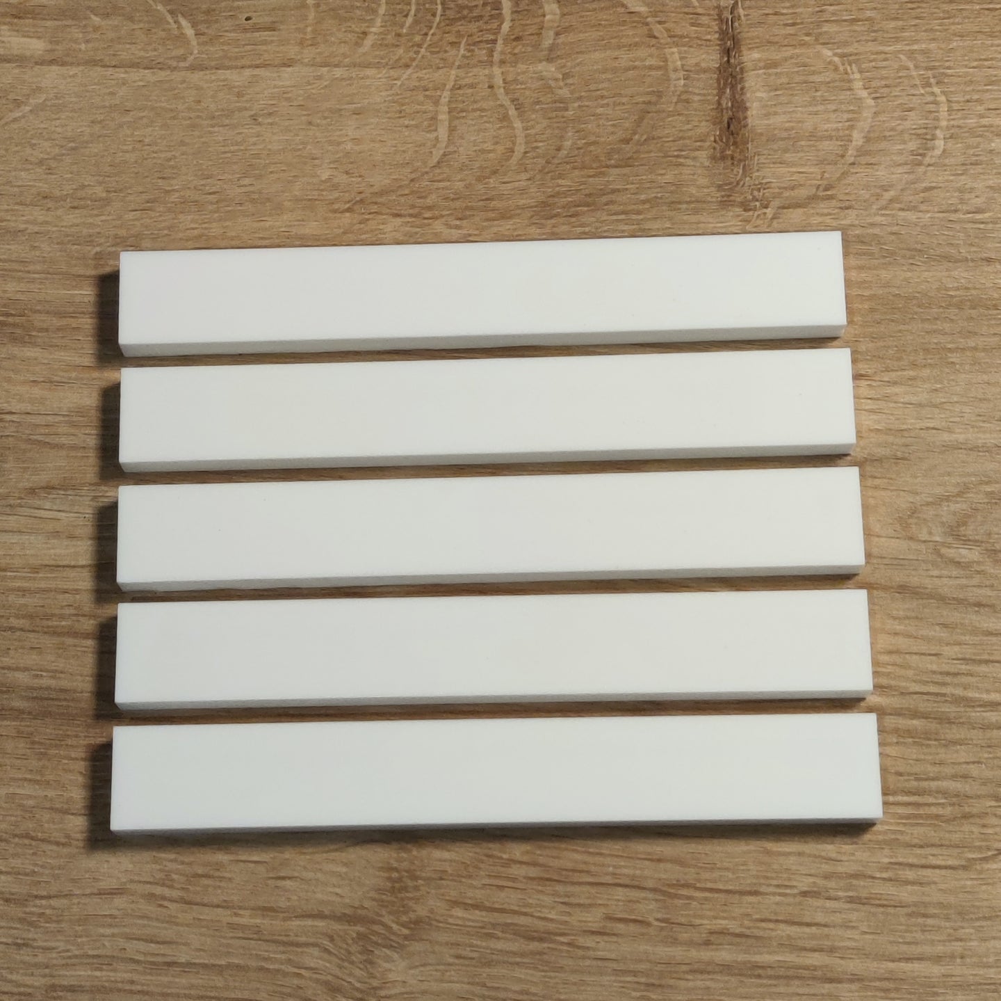 Easy-Sticks Acryl Weiß - 8 Stück - 16 cm Länge, fünf hochglänzende weiße Acryl-Sticks auf einem Holzuntergrund, perfekt für verschiedene Bastelprojekte.