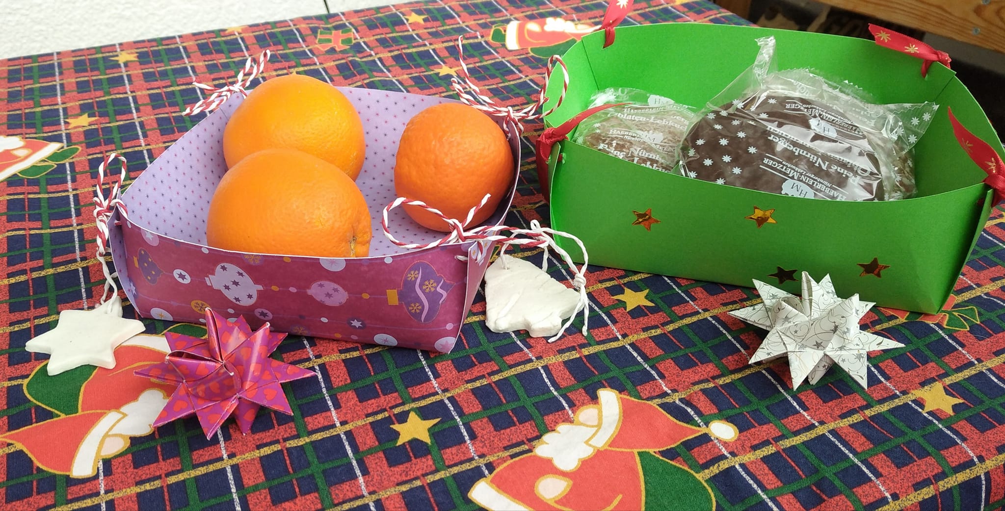 Zwei fröhliche Körbchen in bunten Designs, gefüllt mit Orangen und Keksen, dank der Korb DIY Plotterdatei von easy-sticks.