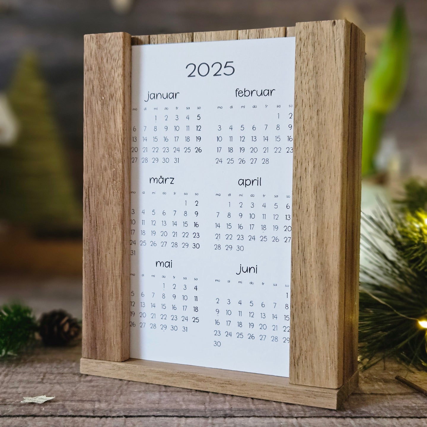 Kreativer DIY Kalender 2026 von easy-sticks, gestaltet mit einem rustikalen Holzständer und umgeben von festlichem Schmuck, ideal als persönliches Geschenk und zur Dekoration.