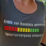 Frau in einem grauen Shirt mit Rundhalsausschnitt, das den Schriftzug "Kritik zur Kenntnis genommen ... Ignoriervorgang eingeleitet" von easy-sticks trägt.