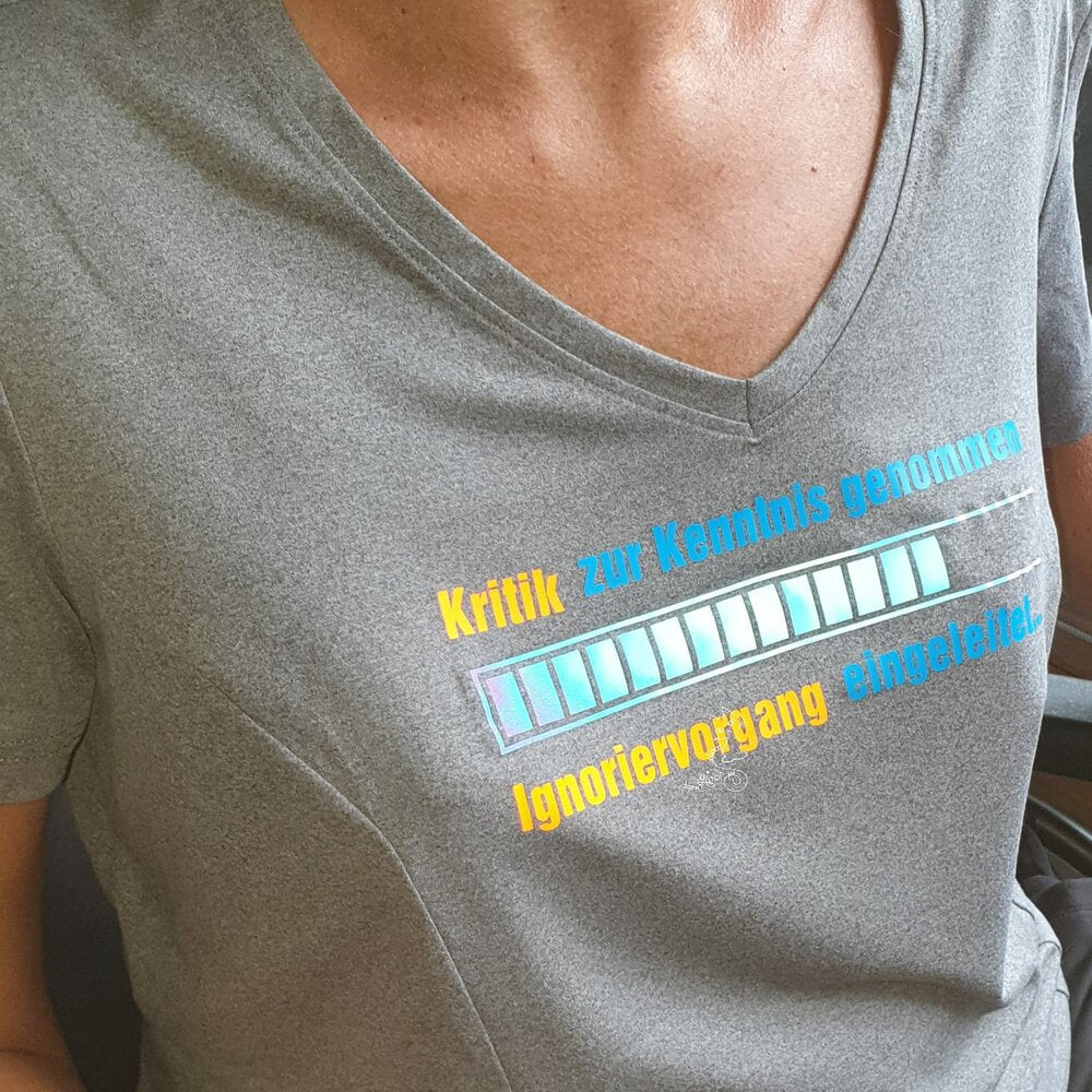 Frau in grauem V-Ausschnitt T-Shirt mit dem kreativen Aufdruck "Kritik zur Kenntnis genommen ... Ignoriervorgang eingeleitet" von easy-sticks.