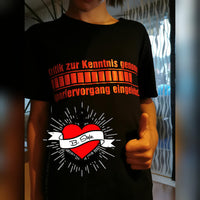 Junge trägt ein schwarzes T-Shirt mit dem Aufdruck "Kritik zur Kenntnis genommen ... Ignoriervorgang eingeleitet" von easy-sticks, während er Daumen hoch zeigt.