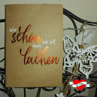 Notizbuch mit dem inspirierenden Text 'Wer schön sein will, muss lachen', designt von easy-sticks, ideal für Notizen und kreative Gedanken.