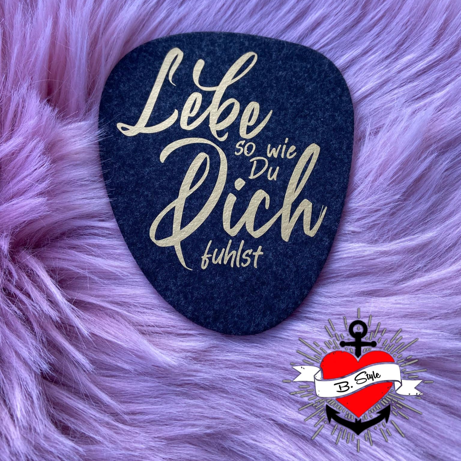 Kreative Plotterdatei "Lebe so wie du dich fühlst" von easy-sticks, präsentiert auf einem eleganten schwarzen Hintergrund mit goldener Schrift auf einem weichen, lilafarbenen Hintergrund. Ideal für DIY-Projekte.