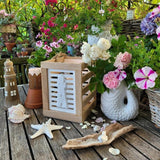 Leuchtturm Laterne in Easy-Sticks Klötzchen Laterne Rahmen auf Gartentisch mit Blumen