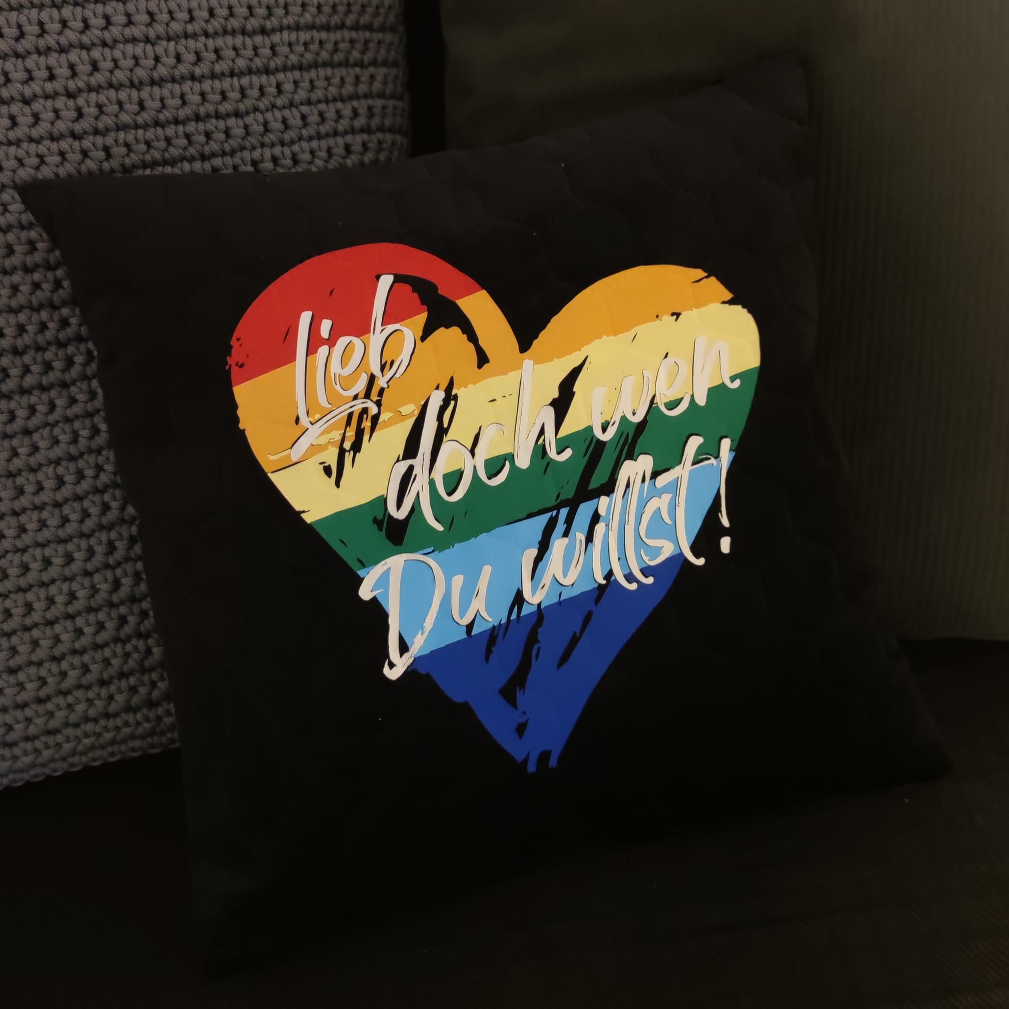 Gemütliches Kissen mit dem Slogan "Lieb doch wen du willst!" und buntem Herzdesign, kreiert von easy-sticks.