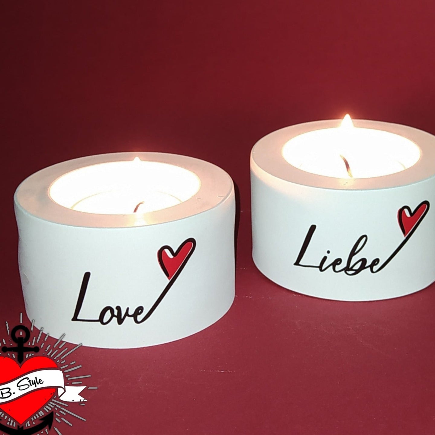 Zwei dekorative Kerzen mit den Aufschriften "Love" und "Liebe" von easy-sticks, strahlend auf rotem Hintergrund, ideal für romantische Anlässe.