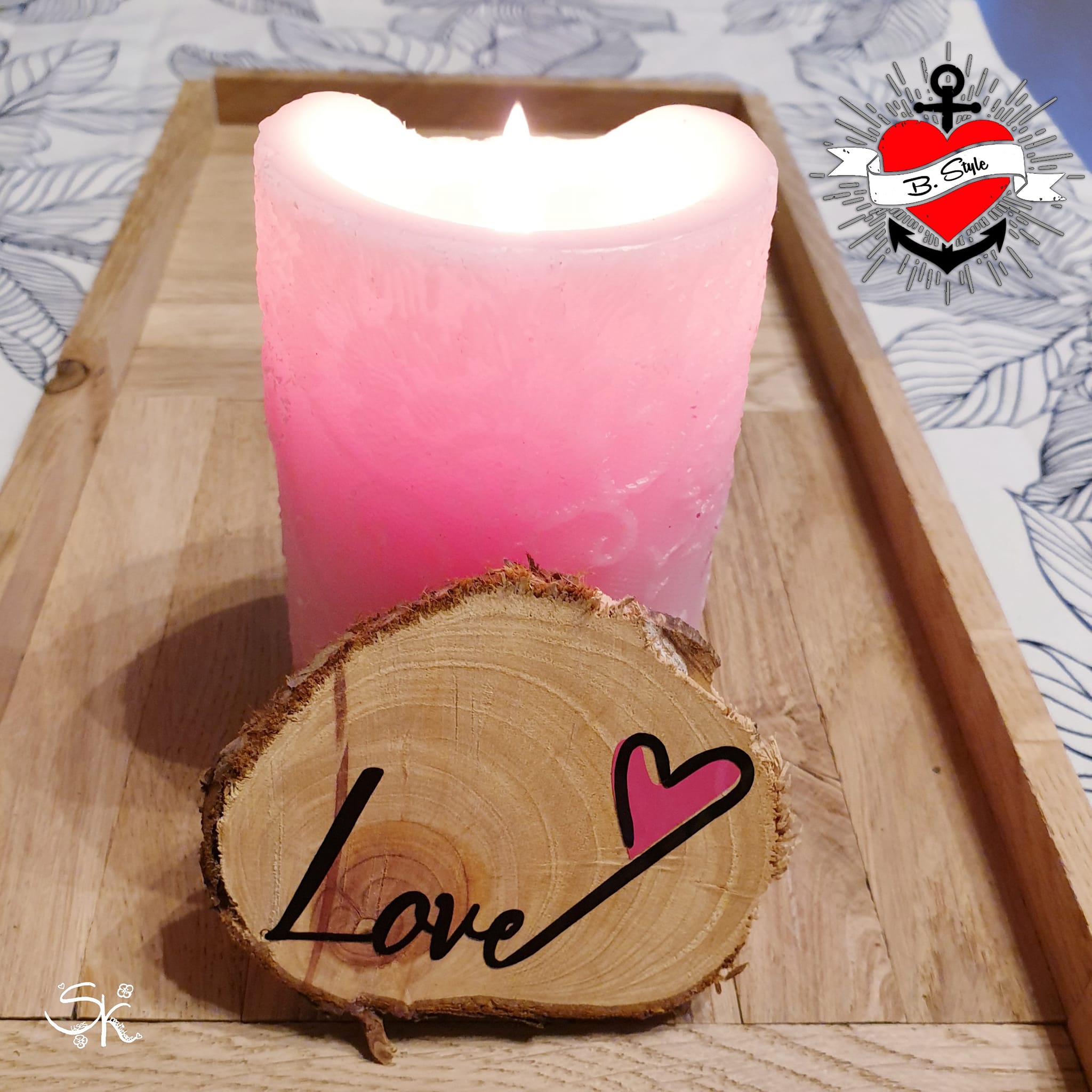 Ein dekorativ gestalteter Holzstück mit der Aufschrift 'Love' und einer niedlichen roten Herzgrafik, inspiriert von der Plotterdatei 'Liebe und Love' von easy-sticks, neben einer brennenden Kerze.