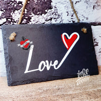 Ein stilvolles Schiefer-Schild mit dem Schriftzug 'Love' und einem roten Herz, basierend auf der Plotterdatei 'Liebe und Love' von easy-sticks. Perfekte Geschenkidee für Verliebte.