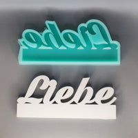 Silikonform für 'Liebe' Schriftzüge in Türkis und Weiß von Easy-Sticks, perfekt für kreative DIY Bastelarbeiten und einzigartige Geschenke.