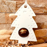 Weißer Tannenbaum als Schokoladenkugelhalter von easy-sticks, dekoriert mit einer Schokoladenkugel, perfekt für Weihnachtsdekoration.