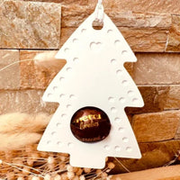 Weißer Tannenbaum als Schokoladenkugelhalter von easy-sticks, dekoriert mit einer Schokoladenkugel, perfekt für Weihnachtsdekoration.