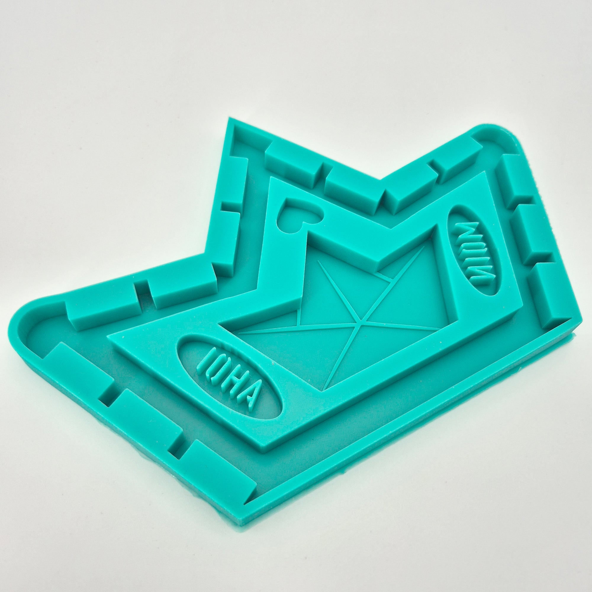 Easy-Sticks 5-in-1 Gießform - Schiffchen in leuchtendem Türkis, gestaltet für das gleichzeitige Gießen von mehreren Formen, darunter ein Boot und verschiedene dekorative Elemente.