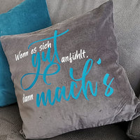 Kuschelkissen in Grau mit dem inspirierenden Spruch "Wenn es sich gut anfühlt, dann mach's" in leuchtendem Türkis, entworfen von easy-sticks.