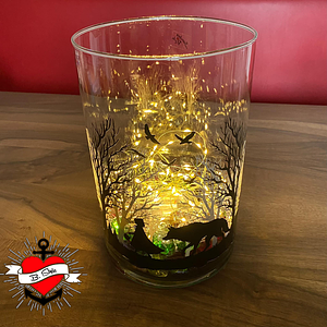 Fantasievoller Glasbehälter, der mit Lichtern geschmückt ist, zeigt eine Silhouette von Rotkäppchen und dem bösen Wolf in einem Wald, entworfen von easy-sticks. Titel: Märchen Rotkäppchen und der böse Wolf Plotter Datei.