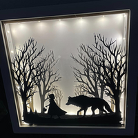 Leuchtendes Deko-Glasbild mit dem Motiv "Märchen Rotkäppchen und der böse Wolf" von easy-sticks, zeigt eine Silhouette von Rotkäppchen und dem Wolf vor einer Baumlandschaft.