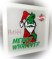 Gerahmte Deko mit einer Illustration eines geheimnisvollen grünen Charakters im Weihnachtsmann-Outfit, der auf einen transparenten Hintergrund zeigt. Ideal für DIY-Projekte mit der "Merry Whatever" Plotterdatei von easy-sticks.
