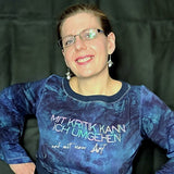 Person in blauer Kleidung, die ein Sweatshirt mit dem Aufdruck "Mit Kritik kann ich umgehen - und mit einer Axt" trägt. Von easy-sticks, ideal für individuelle Designs mit einer Plotterdatei.
