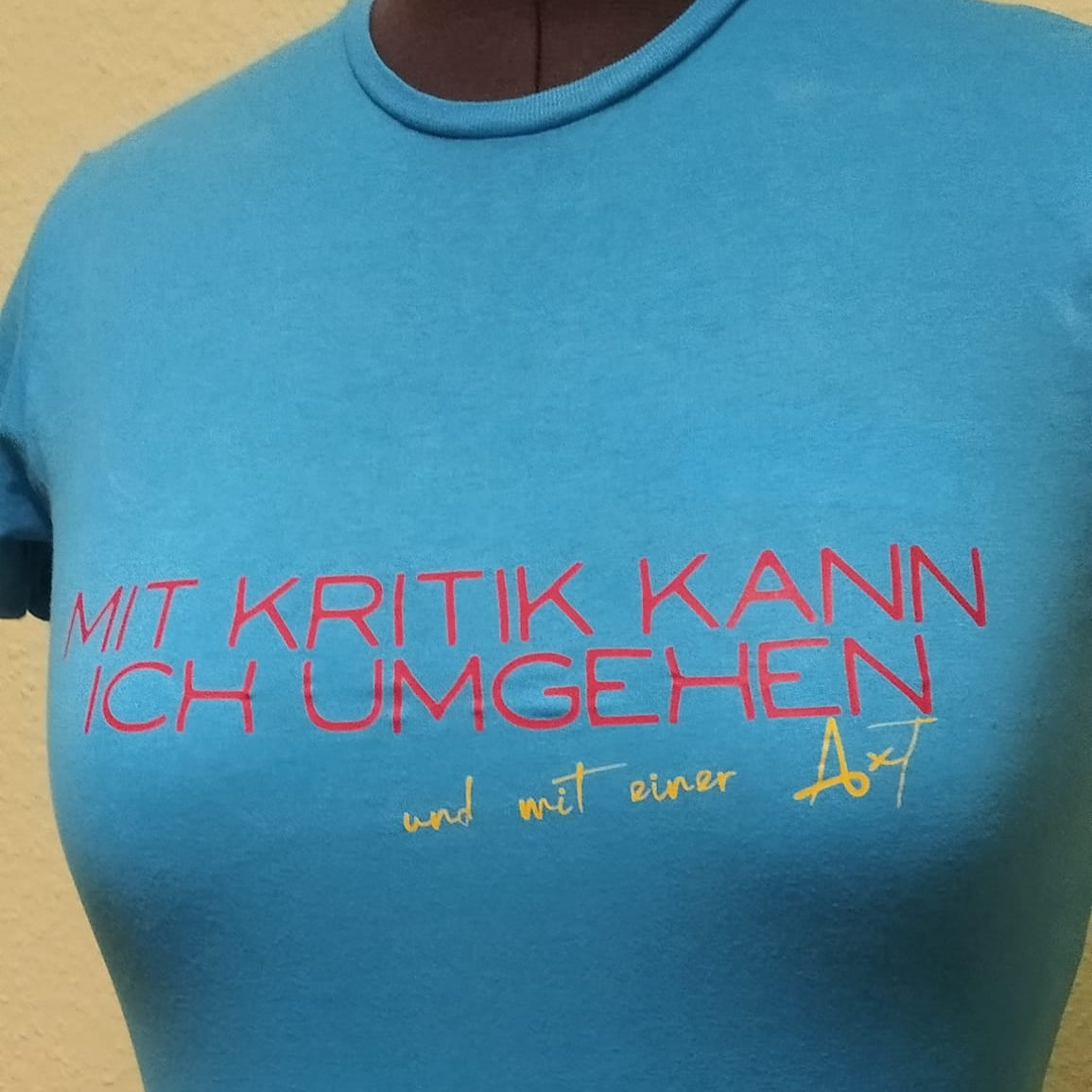 Hellblaues T-Shirt mit dem Schriftzug "Mit Kritik kann ich umgehen - und mit einer Axt", hergestellt von easy-sticks mit der kreativen Plotterdatei.