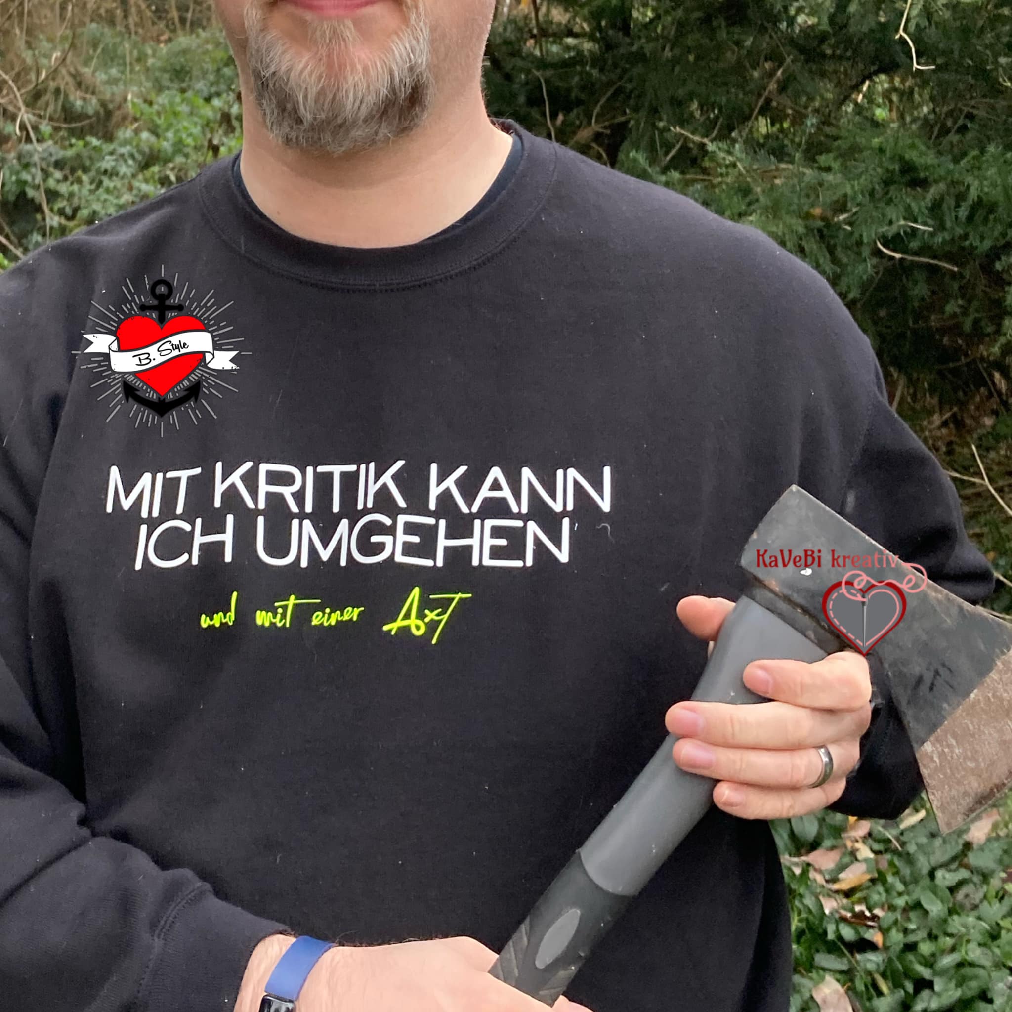 Mann trägt ein schwarzes Sweatshirt mit dem provokanten Text "Mit Kritik kann ich umgehen - und mit einer Axt", erstellt von easy-sticks und inspiriert von der Plotterdatei.