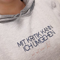 Gemütlicher Hoodie in Grautönen, verziert mit dem Spruch "Mit Kritik kann ich umgehen - und mit einer Axt", einem Design von easy-sticks basierend auf der Plotterdatei.