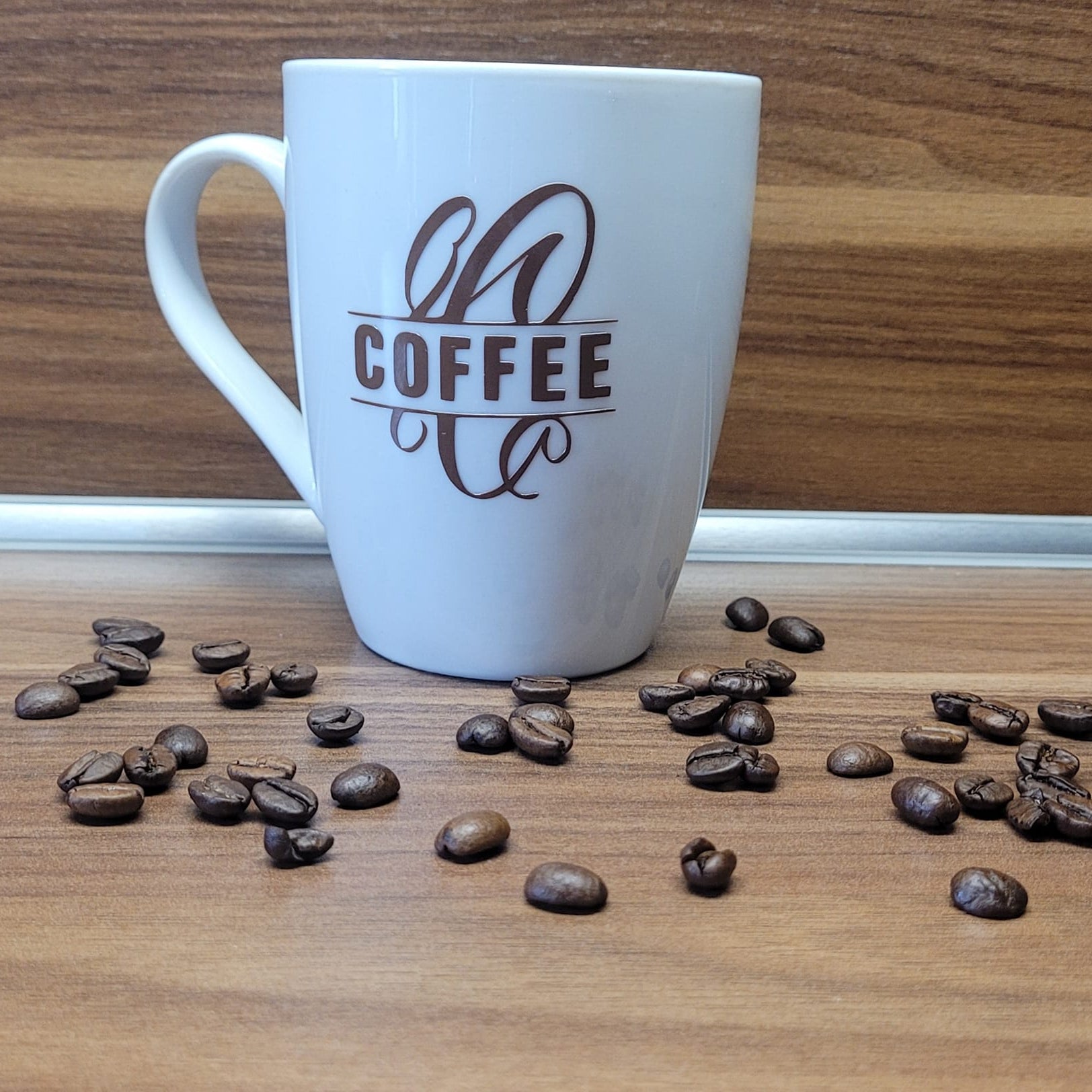 Monogramm "C" Plotterdatei von easy-sticks, künstlerisch dargestellt auf einer Kaffeetasse, umgeben von Kaffeebohnen und ideal für personalisierte Geschenke.
