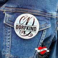 Monogramm "D" Plotterdatei von easy-sticks auf einem Anstecker, der das Wort "DORFKIND" auf einem blauen Denimstoff zeigt. Silikongieform.