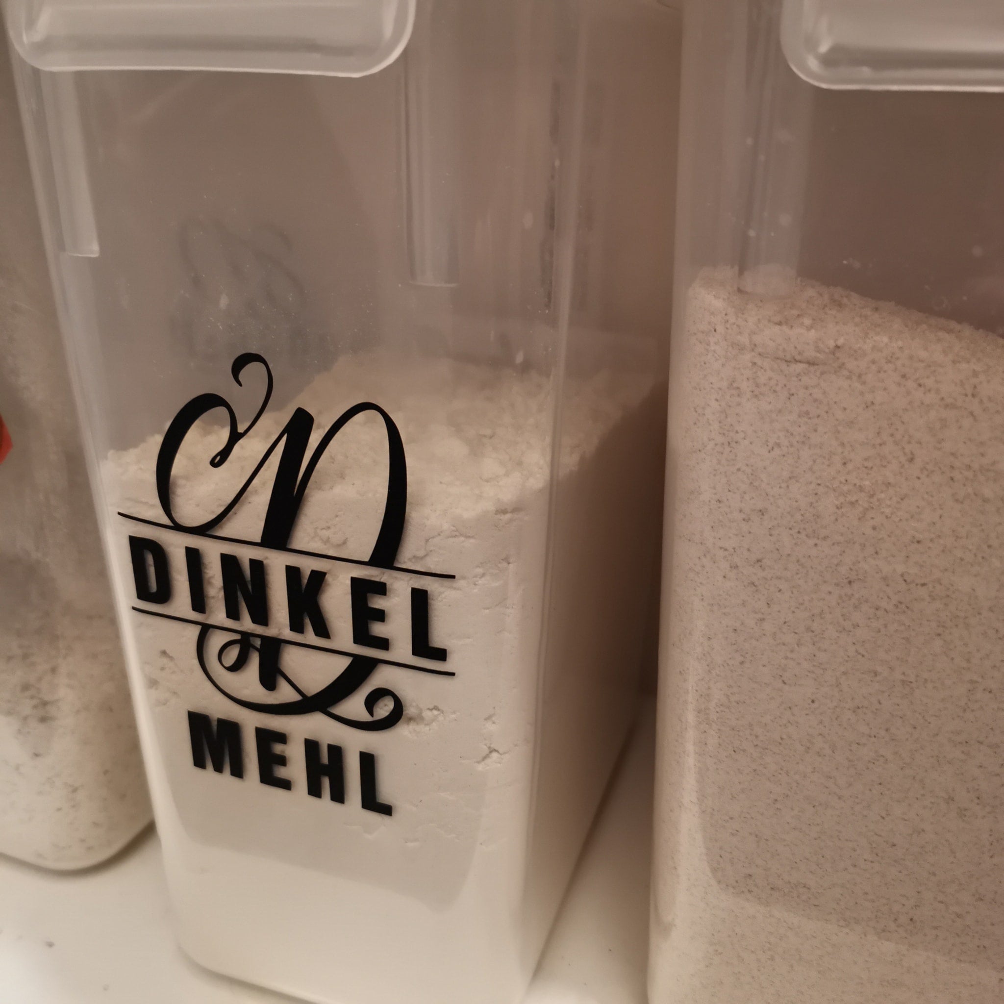 Monogramm 'D' Plotterdatei von easy-sticks - Aufbewahrungsbehälter mit einer stilvollen Beschriftung 'DINKEL MEHL' im künstlerischen Schriftzug.