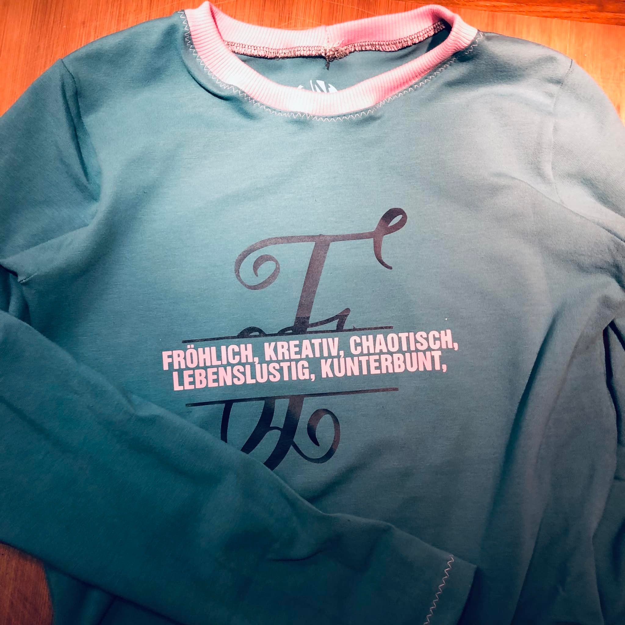 Bequemes Sweatshirt mit pinker Schrift und monogrammlicher "F" Plotterdatei von easy-sticks, perfekt für individuelle Modekreationen.