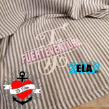Kreative Stoffgestaltung mit der Monogramm 'F' Plotterdatei von easy-sticks, wo 'FUERTEVENTURA' stilvoll in pinker Schrift auf einem gestreiften Hintergrund zur Geltung kommt.