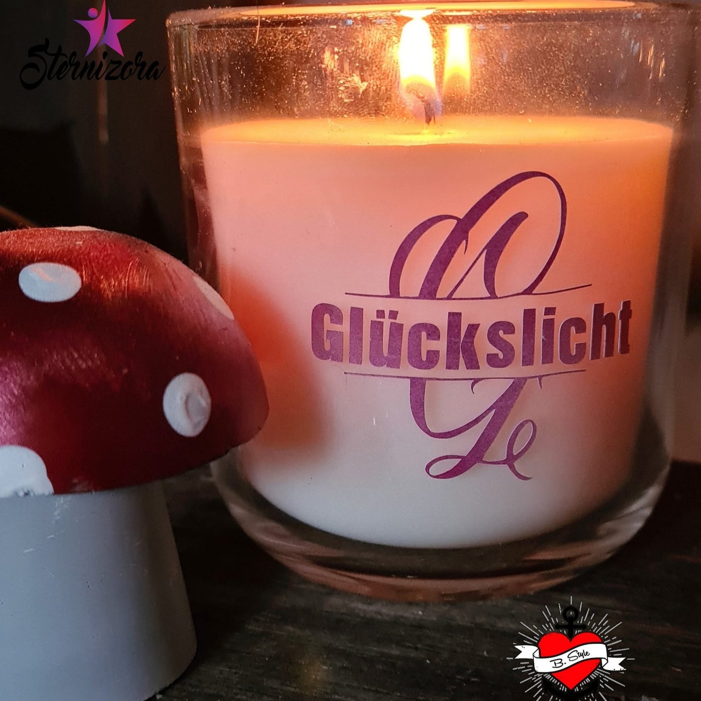 Monogramm 'G' Plotterdatei von easy-sticks, dekorative Kerze mit dem Schriftzug GLÜCKSLICHT in lila mit stilisierten Buchstaben auf einem rustikalen Hintergrund.